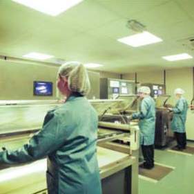 Workers use chemical etching machines to produce etched components